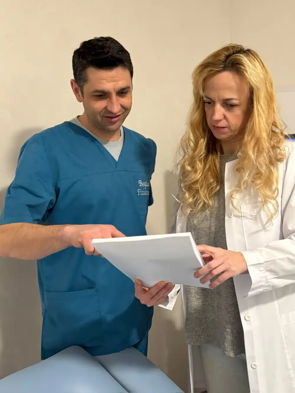 fizioterapeut si medic analizand dosarul unui pacient cu hernie de disc