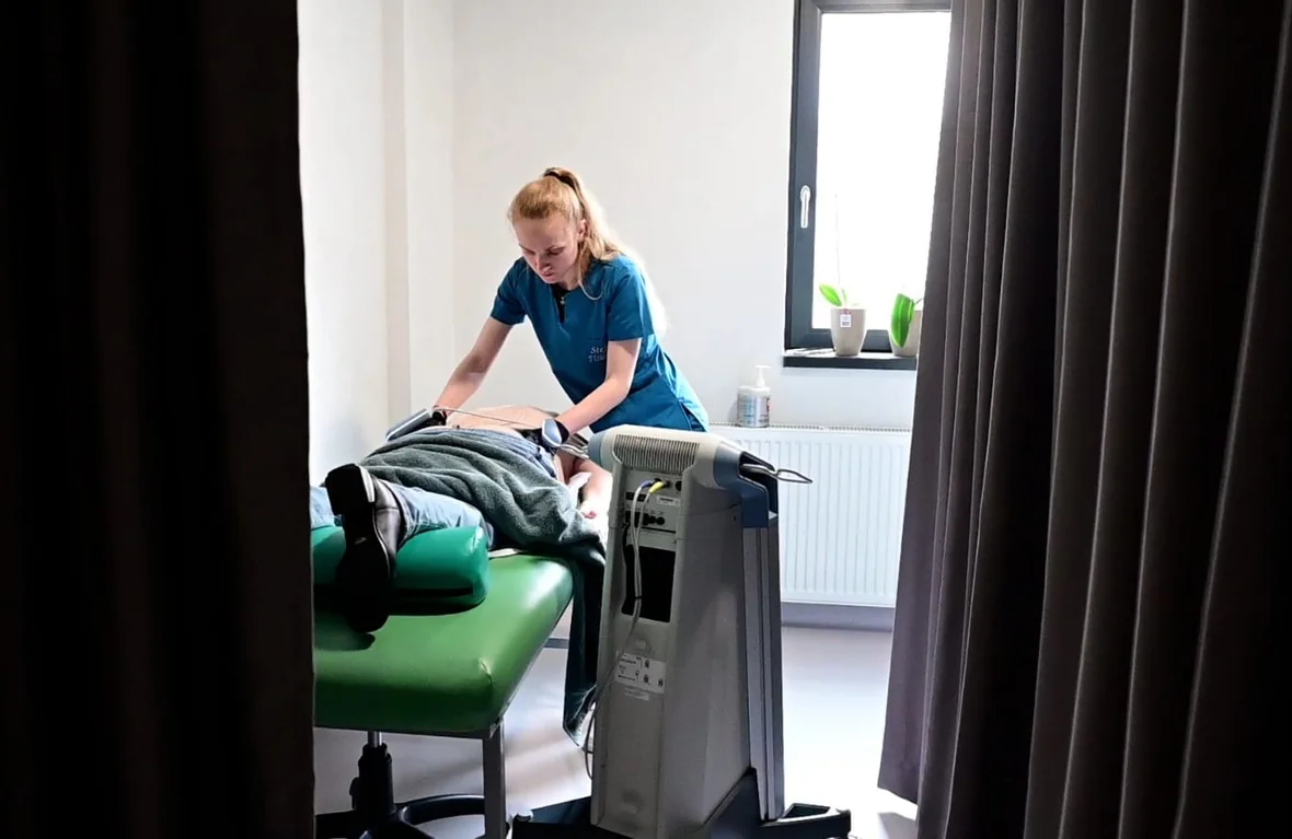 Fizioterapeut aplicând electrozi unui pacient pentru o ședință de electroterapie – Clinica Kinetoterapia Piatra-Neamț