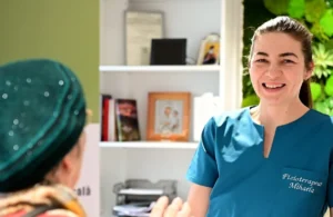 Fizioterapeutul Mihaela discutând cu un pacient în cadrul unei consultații