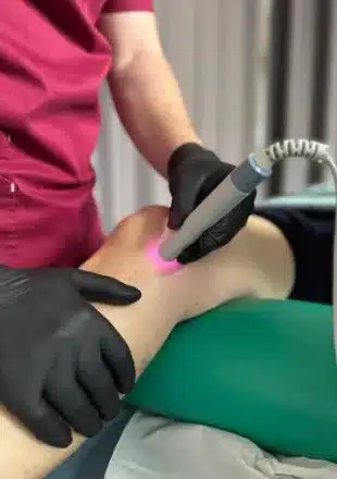 Aplicare de laserterapie pe genunchi, cu sonda laser – Clinica Kinetoterapia Piatra-Neamț